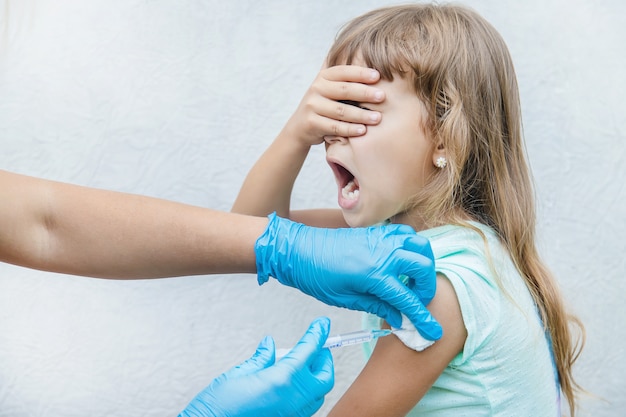 El médico le da al niño una inyección en el brazo.