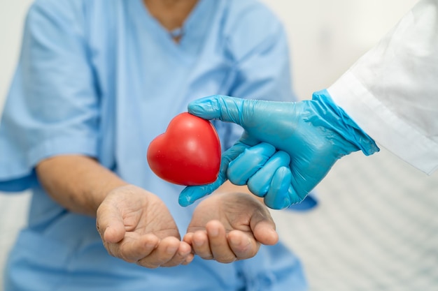 Médico dá coração vermelho a idosa asiática ou idosa idosa paciente saudável conceito médico forte