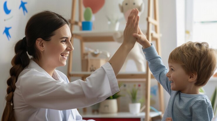 Un médico le da un "high five" a un niño en una sala de juegos