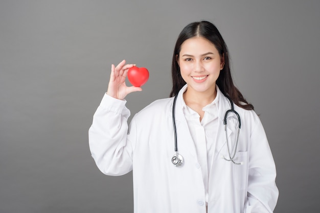 Médico da mulher está segurando coração vermelho