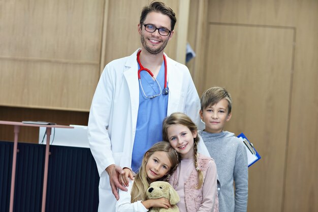 médico dando la bienvenida a los niños en la clínica