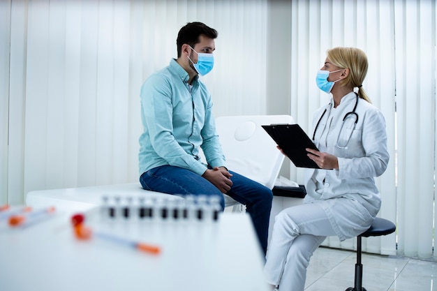 Foto médico dando consejos a un joven para mantenerse saludable durante la pandemia del virus corona.