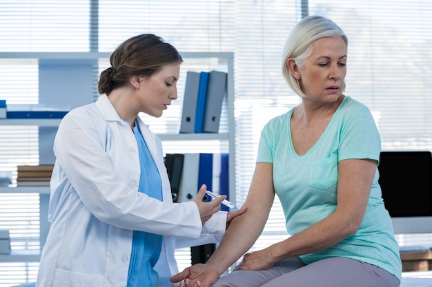 Médico dando injeção ao paciente