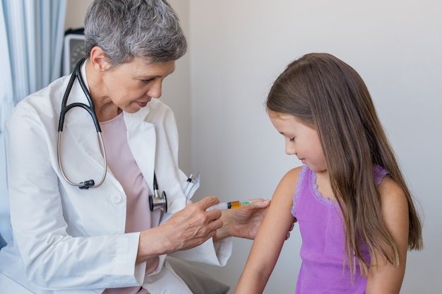 Médico dando injeção de criança