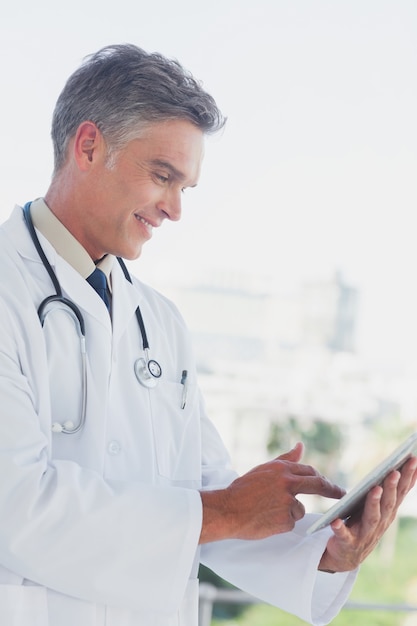 Médico de cabelos grisalhos usando tablet digital