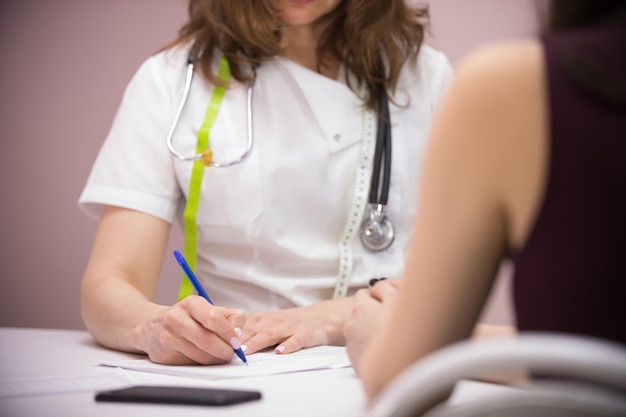 Médico de clínica de beleza de cosmetologia e paciente tomando notas