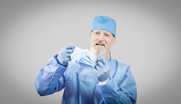 Médico de doenças infecciosas de macacão protetor azul coloca uma máscara protetora azul