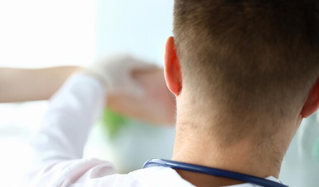 Médico de frente com luvas a examinar a pele dos doentes