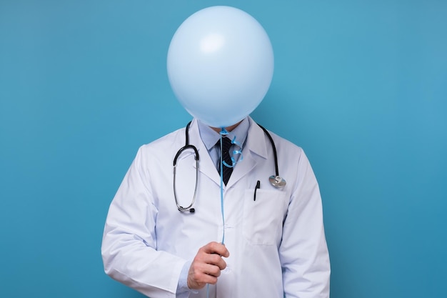 Foto médico de jaleco branco com estetoscópio se esconde atrás de um balão