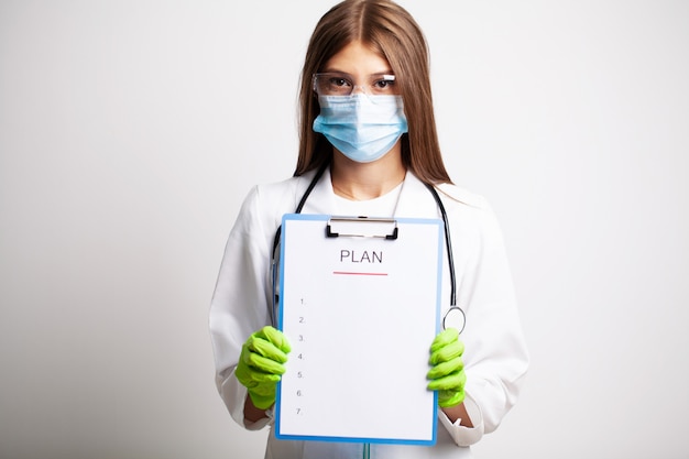 Médico de jaleco branco mantém carta com um plano de ação