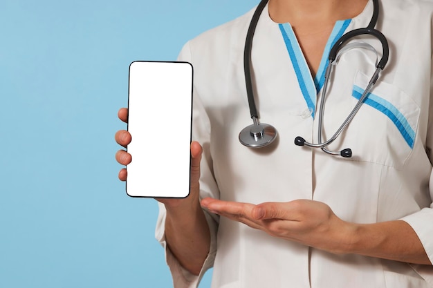 Médico de mulher com smartphone. Médica com telefone celular. Enfermeira segurando o celular na mão