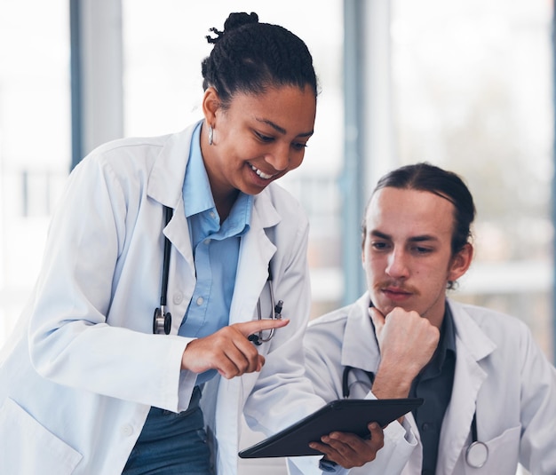 Médico de pessoas e mentor com tablet no hospital para consulta, ensino ou treinamento Equipe diversificada homem e mulher em cuidados médicos em estratégia de saúde ou resultados para diagnóstico e clínica do paciente