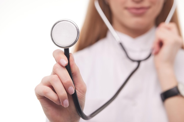 Médico de saúde e medicina em jaleco branco segurando estetoscópio no espaço de cópia de fundo azul