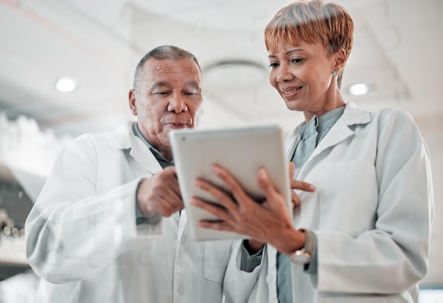 Médico de tablet e equipe conversando no hospital para opinião de colaboração ou aconselhamento sobre resultados Homem e mulher ou equipe médica com tecnologia para planejamento de saúde, pesquisa on-line ou aplicativo de telessaúde