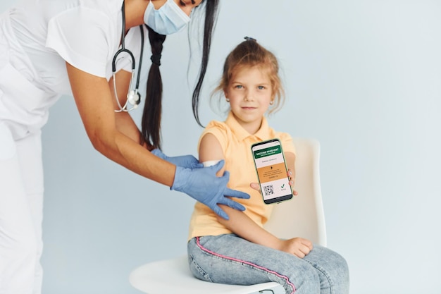 Médico de uniforme fazendo vacinação para a garotinha