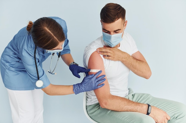 Médico de uniforme fazendo vacinação para o paciente