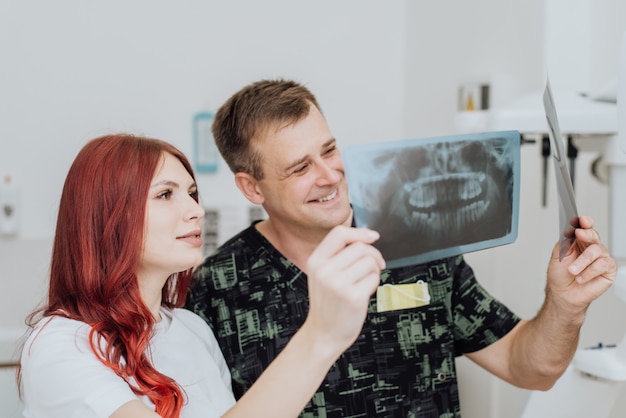El médico dentista con un asistente revisa el ortopantomograma de rayos X. Radiografía panorámica dental