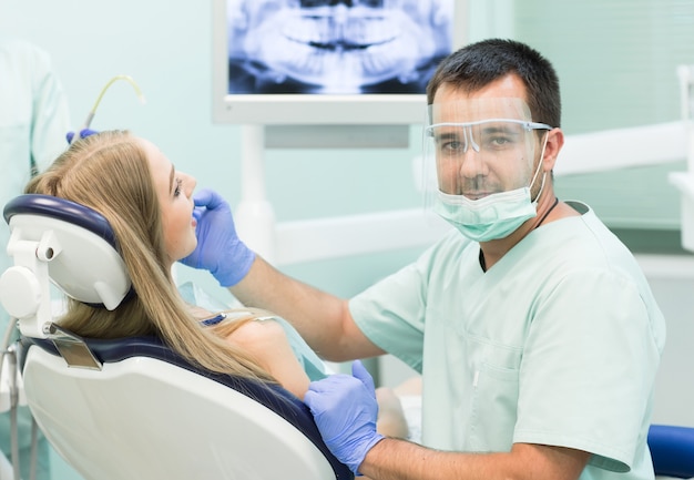 Médico dentista com um trabalho de assistente em uma clínica odontológica.