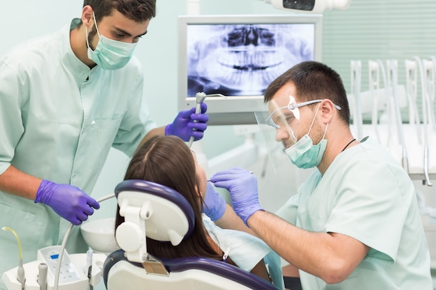 Médico dentista com um trabalho de assistente em uma clínica odontológica.