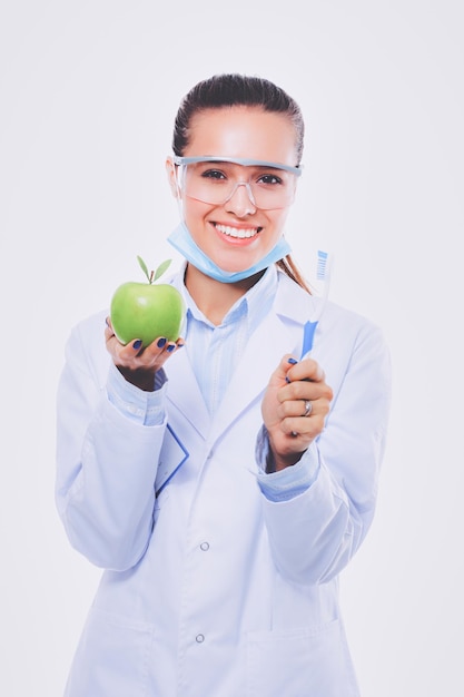 Médico dentista mulher segura maçã verde fresca na mão e escova de dentes médicos dentista mulher faz