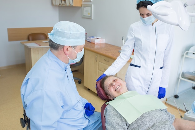 Médico dentista con paciente anciano en clínica