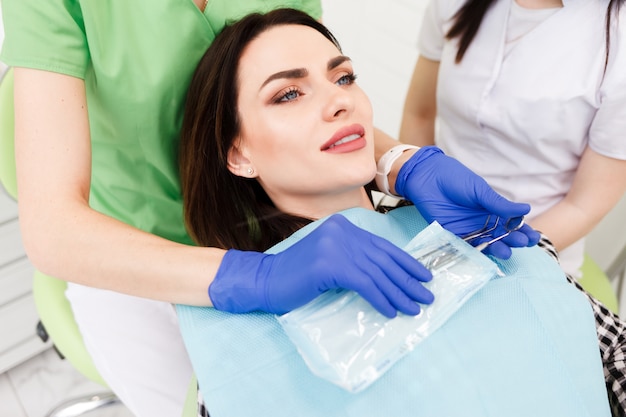 Médico dentista remove instrumentos estéreis de um saco