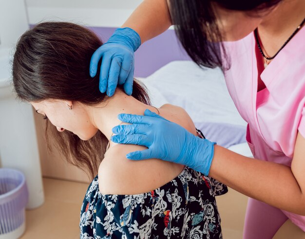 Médico dermatólogo examina la marca de nacimiento del paciente. Comprobación de lunares benignos.