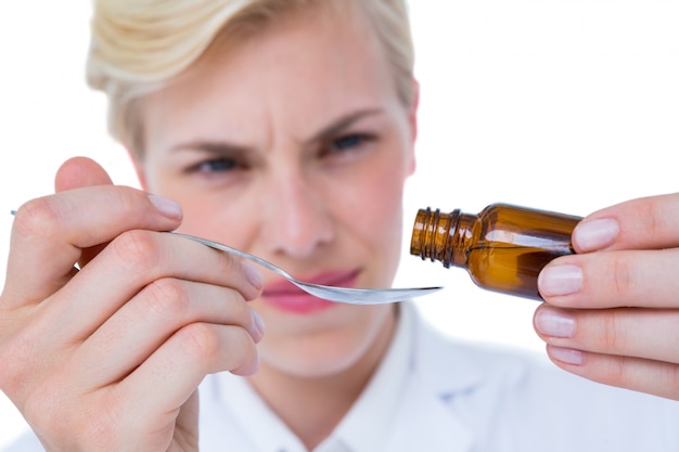 Foto médico derramando remédio em colher