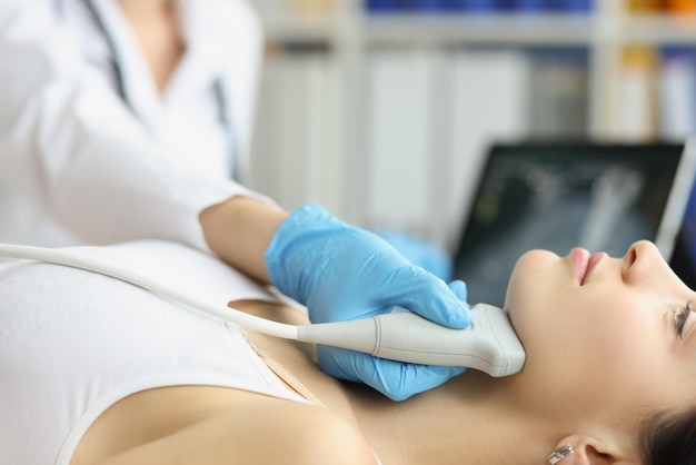 El médico diagnostica la glándula tiroides en el primer plano de la máquina de ultrasonido