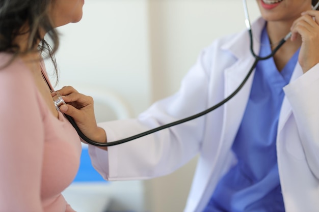 Médico diagnosticando paciente idosa com estetoscópio Mulher idosa visita médico para exame na sala de exame do hospital
