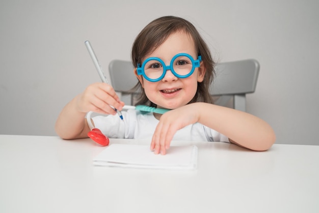 El médico dice cómo tratar a todos el niño está jugando al doctor gracioso un niño con gafas escribe s ...