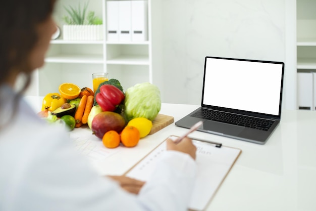 El médico dietista tiene consulta en línea usando computadora portátil