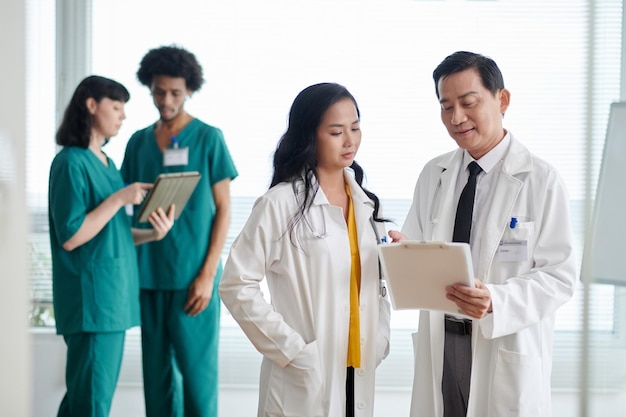 Foto médico discutindo detalhes da prescrição com colega de trabalho