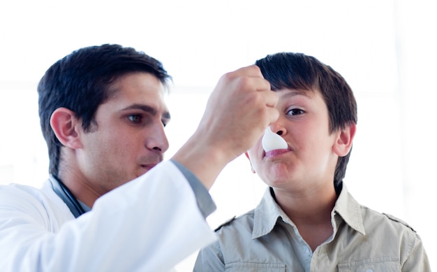 Médico do sexo masculino dando remédio a um garotinho