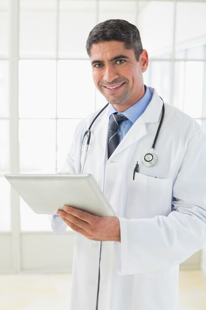 Médico do sexo masculino sorrindo com comprimido digital