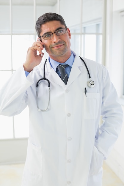 Foto médico do sexo masculino usando o telefone móvel no hospital