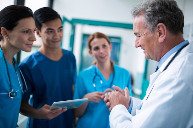 Foto médico e cirurgiões interagindo sagacidade no corredor