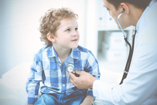 Médico e criança paciente. Médico examinando garotinho. Visita médica regular na clínica. Conceito de medicina e cuidados de saúde.