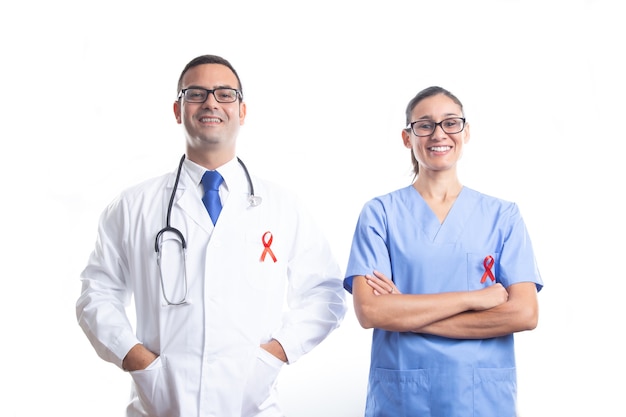 Médico e enfermeira com fita vermelha da SIDA em branco.