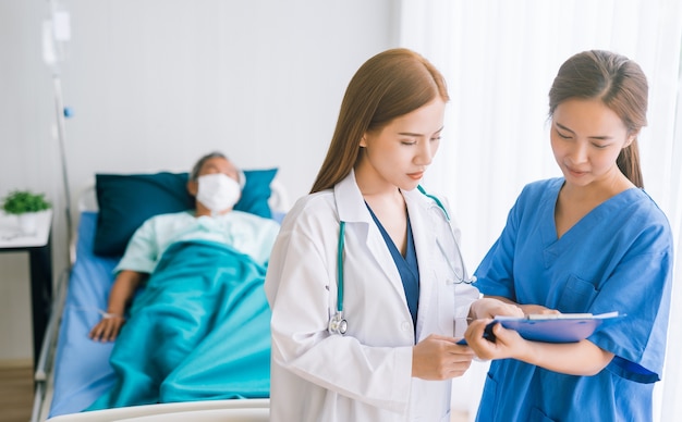 Foto médico e enfermeira fazendo em um quarto no hospital e visitando um paciente