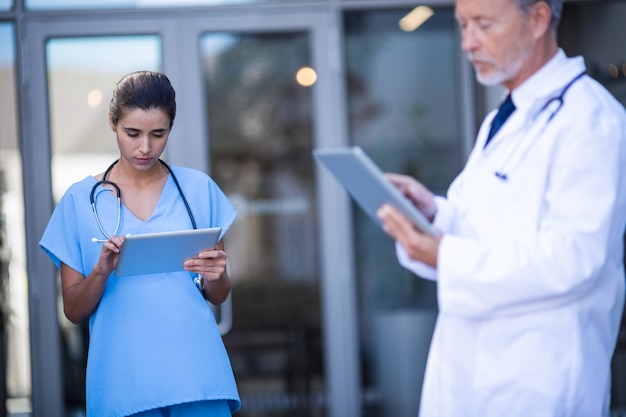 Médico e enfermeira usando tablet digital