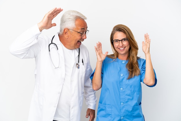 Foto médico e enfermeiro de meia-idade isolado no fundo branco com expressão facial de surpresa e choque