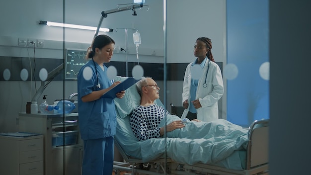 Foto médico e enfermeiro examinando o paciente na clínica médica