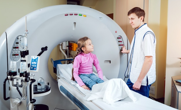 Médico e menina na sala de tomografia computadorizada