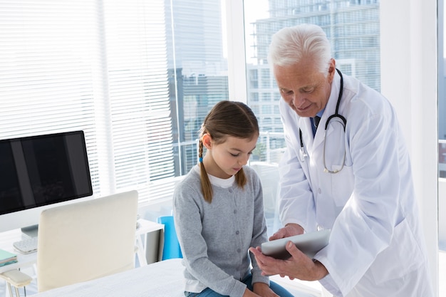 Médico e paciente discutindo sobre tablet digital