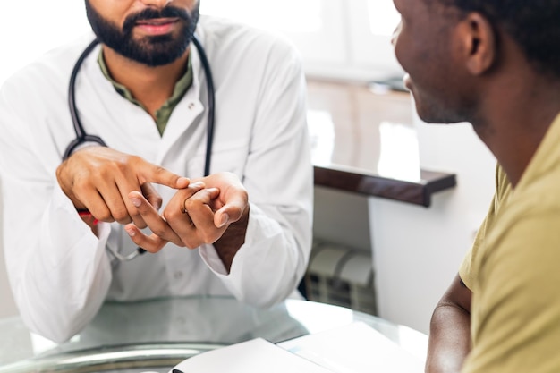 Médico e paciente do sexo masculino conversando na consulta do consultório para tratamento adicional