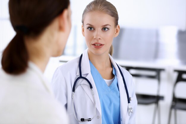 Médico e paciente durante a consulta médico no trabalho preenchendo o registro do histórico de medicamentos enquanto está sentado em uma sessão de fotos do hospital de emergência conceito de medicina e saúde