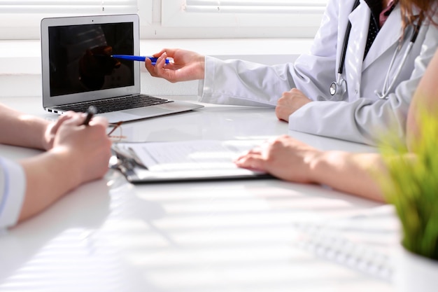 Médico e paciente estão discutindo algo apenas com as mãos na mesa