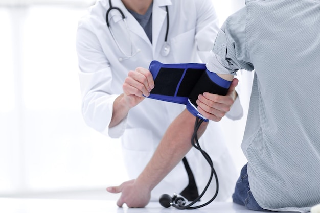 Foto médico e paciente medindo pressão arterial