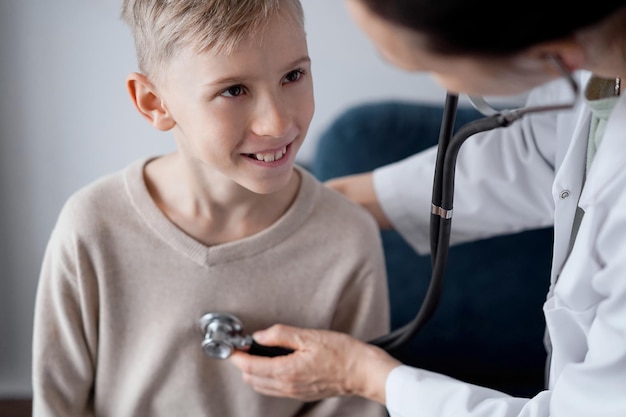 Médico e paciente menino sorridente feliz em inspeção médica em casa. Medicina, conceitos de saúde